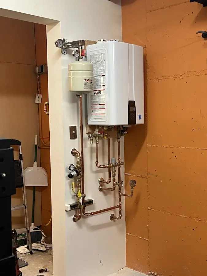 Plumbing technician inspecting water heater connections in Gilbert